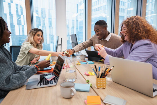 Cheerful diverse team discussing ideas in office