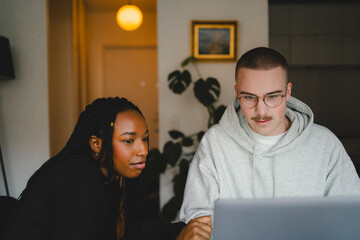 Young male and female entrepreneurs working on laptop at home office