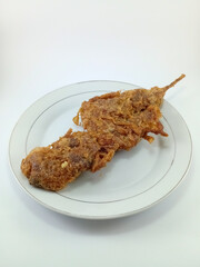 Liver Battered Fried Skewer on White Plate and Background: A Crispy and Savory Delight of Liver, Expertly Presented in a Minimalist Setting, Perfect for Culinary Enthusiasts to Enjoy and Appreciate