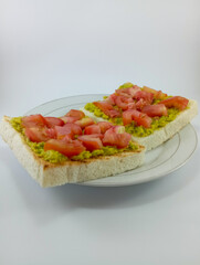 Mashed Avocado and Diced Tomato on Toast: A delicious and nutritious breakfast choice featuring creamy mashed avocado and juicy diced tomato atop crispy toast on White Background