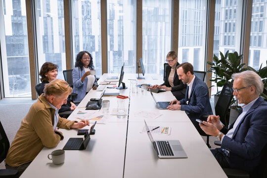 Group of multiracial business people sitting over conference table in office