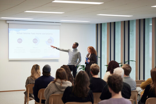 Multiracial coworkers explaining strategies to colleagues in office