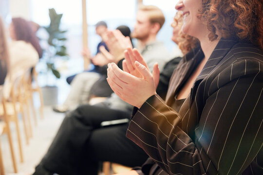 Midsection of young businesswoman applauding during presentation in office
