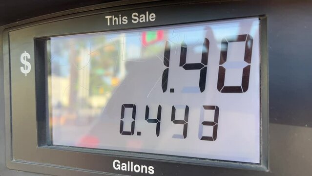Gas price meter display rising with cars in reflection on 7/4/2024