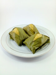 Beppa Oto: A Traditional Bugis Dessert from Sulawesi, Indonesia. Made of Banana and Wrapped in Banana Leaf, Presented on a White Background, Highlighting Rich Cultural Heritage and Culinary Tradition