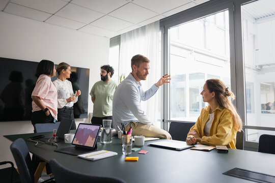 Multiracial coworkers discussing ideas in meeting room