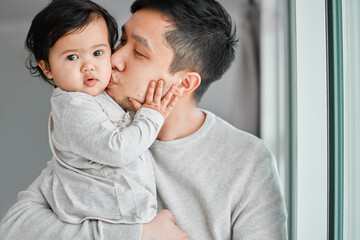 Dad, baby portrait and hug with kiss for care, development and calm morning in family home. Asian father, infant daughter and embrace for parent support or trust, love bonding and growth in apartment