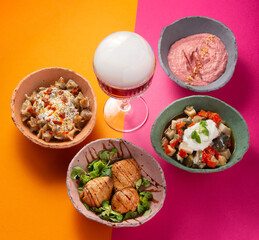 Set of vegetarian bowls on a vibrant pink/orange background with an explosion drink. Modern concept.