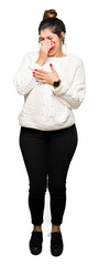 Young beautiful woman wearing winter sweater smelling something stinky and disgusting, intolerable...
