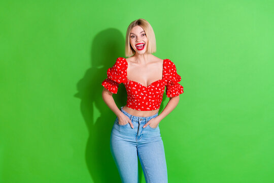 Fototapeta Photo of stunning lovely nice girl woman wear red stylish clothes hands pockets isolated on green color background