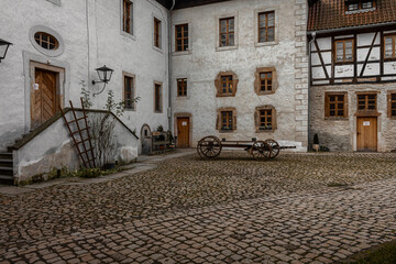 hof eines bauernhofs mit arbeitsmaterial für die ernte und schlafräume mit fenstern