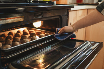 Cookies baking in the oven with hand and oven mit