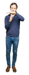 Middle age handsome man wearing a sweater Doing time out gesture with hands, frustrated and serious...