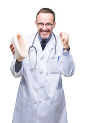 Middle age senior hoary doctor man holding neck collar over isolated background screaming proud and celebrating victory and success very excited, cheering emotion