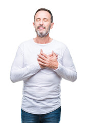 Middle age hoary senior man wearing white t-shirt over isolated background smiling with hands on chest with closed eyes and grateful gesture on face. Health concept.