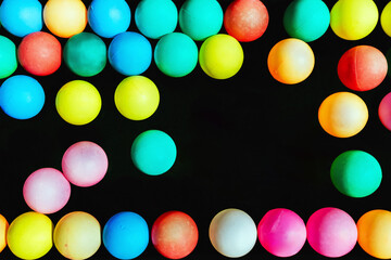 Top view of many colorful plastic balls on water. View of colored sponge balls. Many colorful balls as background. Lots of colorful balls for children to play in the water park. Toy pool for kids.