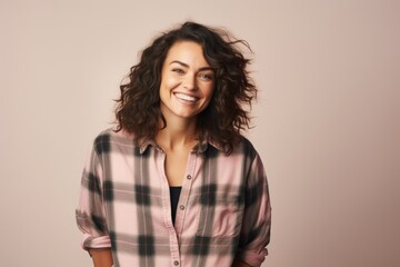 Fototapeta premium Portrait of a happy woman in her 30s wearing a comfy flannel shirt on pastel gray background