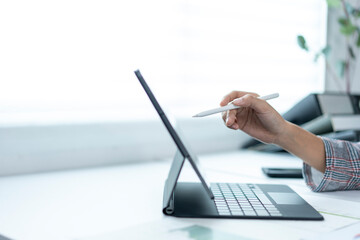 A person is using a tablet with a pen on it