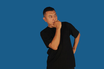 Mature Asian man thinking with pensive expression wearing black shirt with hand on chin
