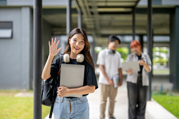 A young woman is walking down a sidewalk with a backpack and a laptop