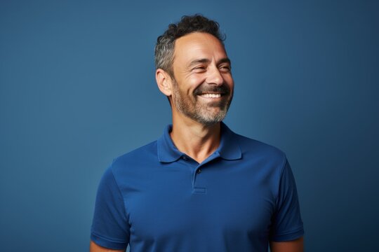 Portrait of a satisfied man in his 40s wearing a sporty polo shirt isolated in soft blue background