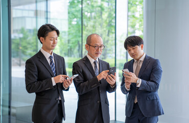 スマートフォン入力で考える男性ビジネスマン