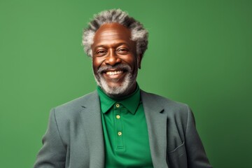 Portrait of a satisfied afro-american man in his 50s wearing a chic cardigan while standing against soft green background