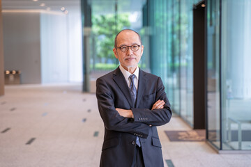 腕組みするシニア男性ビジネスマン-カメラ目線