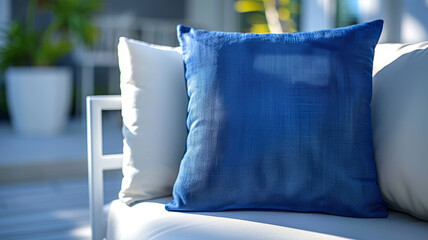 A blue pillow placed on a white couch in a modern indoor setting.