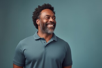 Fototapeta premium Portrait of a blissful afro-american man in his 40s wearing a breathable golf polo over soft gray background