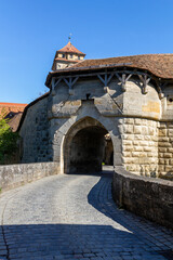 Obraz premium das berühmte Spitaltor mit historischem Wehrgang am Rande der Altstadt von Rothenburg ob der Tauber, Deutschland