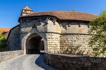 Obraz premium das berühmte Spitaltor mit historischem Wehrgang am Rande der Altstadt von Rothenburg ob der Tauber, Deutschland