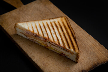 club sandwich on a wooden board on a dark background