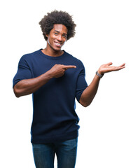 Afro american man over isolated background amazed and smiling to the camera while presenting with...