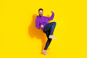 Fototapeta na wymiar Photo of overjoyed funny man wear violet trendy clothes raise hands yes isolated on yellow color background