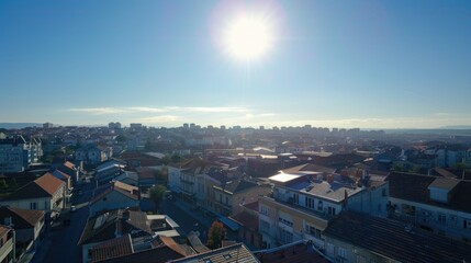 A cityscape at midday, with clear skies and bright sunlight casting sharp shadows on the city streets and rooftops.