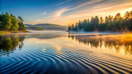 Fototapeta premium Serene natural landscape featuring gentle undulating waves rippling across the tranquil glass-like surface of a misty dawn lake.