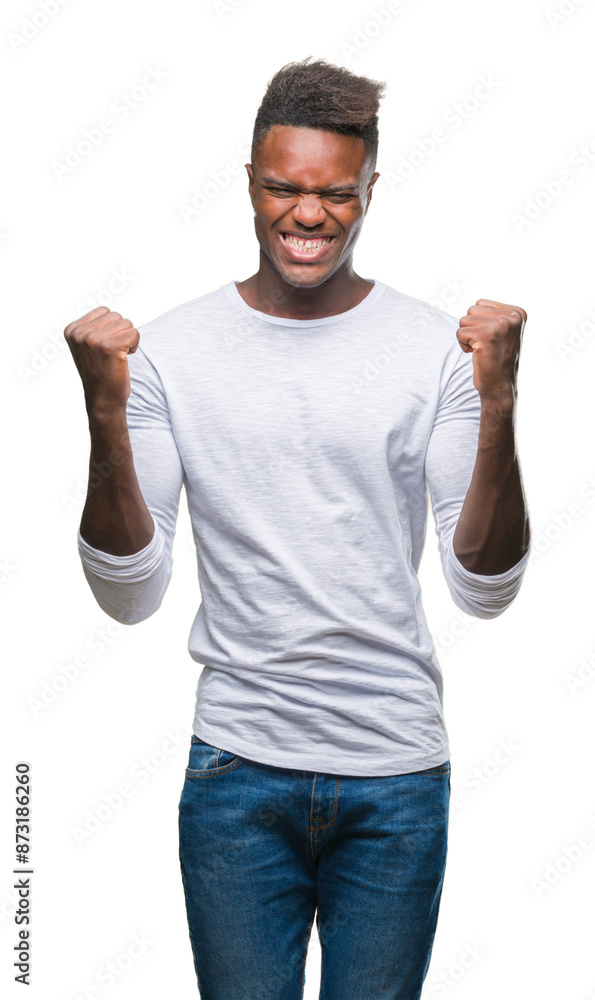 Wall mural Young african american man over isolated background celebrating surprised and amazed for success with arms raised and open eyes. Winner concept.