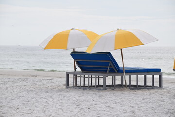 beach chairs blue and yellow white umbrellas on the beach