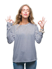 Beautiful young blonde woman wearing stripes sweater over isolated background relax and smiling with eyes closed doing meditation gesture with fingers. Yoga concept.