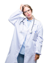 Beautiful young blonde doctor woman wearing medical uniform over isolated background confuse and wonder about question. Uncertain with doubt, thinking with hand on head. Pensive concept.