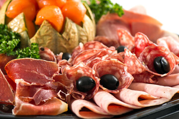 Plateau de charcuterie avec saucisson et melon pour un apéritif dinatoire en été