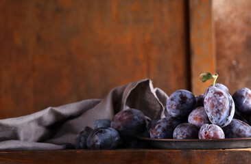 fresh organic plums on wooden table