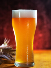 Cold refreshing beer glass with drops of water on a wooden table