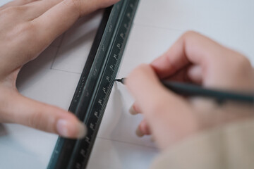 The architect meticulously drafted the blueprint using a ruler to ensure precise scale in the...