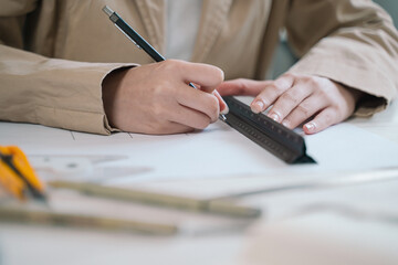 The architect meticulously drafted the blueprint using a ruler to ensure precise scale in the...