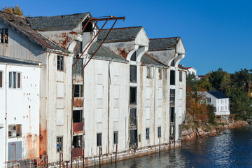 Coastal Norwegian with abandoned white wooden port barn