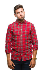 Fototapeta premium Young handsome man over isolated background puffing cheeks with funny face. Mouth inflated with air, crazy expression.
