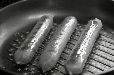 Tasty sausages and vegetables isolated over solid background. Black and white monochrome photo