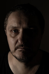 Portrait of an adult man with a beard in close-up on a black background